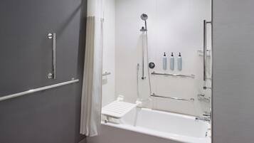 A modern bathroom with a bathtub, shower, and toilet.