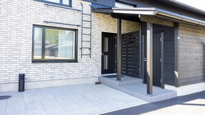 Een modern gebouw met een met baksteen beklede gevel, grote ramen en een overdekte entree.