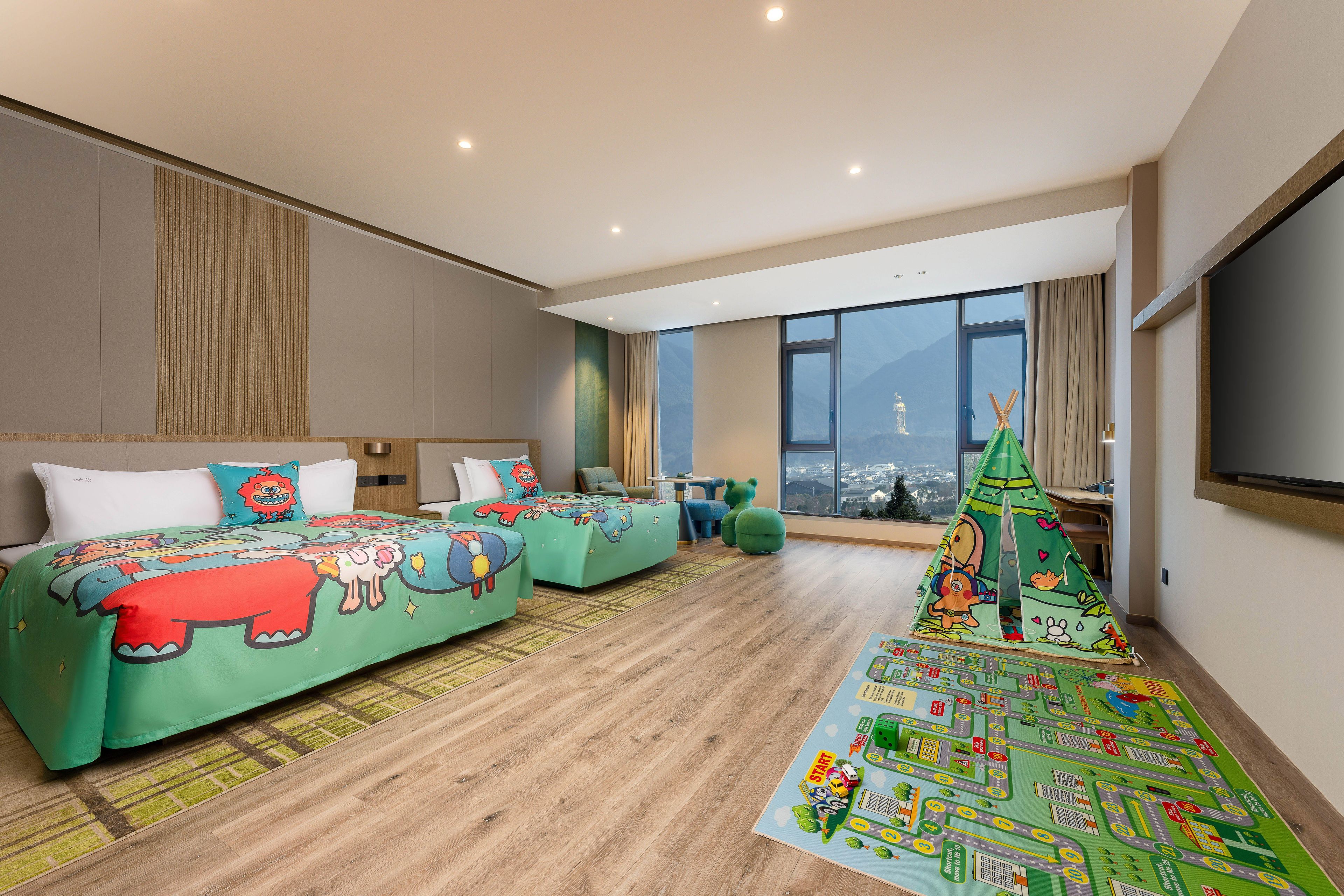 Habitación de hotel moderna con una cama grande, un sofá, un espacio de juegos y vistas a la ciudad.