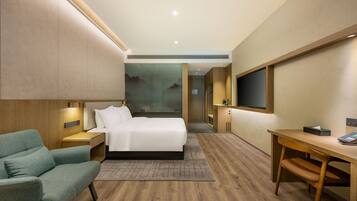 Een moderne hotelkamer met een bed, een bureau, een stoel en een televisie.