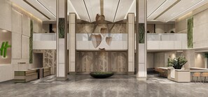 Um lobby moderno com um balcão de recepção central, áreas de estar e elementos decorativos como um grande vaso de plantas e arte abstrata na parede.