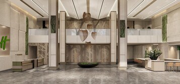 Un vestíbulo moderno con un mostrador de recepción central, zonas de estar y elementos decorativos como una gran jardinera y arte abstracto en la pared.