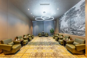 A conference room with a patterned carpet, green upholstered chairs, and a large mural on the wall. - Holiday Inn Jiuhua Mountain Hot Spring (Chizhou)