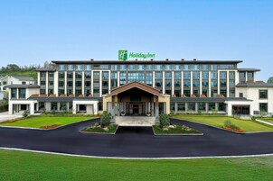 Um hotel Holiday Inn com fachada moderna, vários andares e uma entrada central.