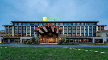 A Holiday Inn hotel with a modern facade, multiple floors, and a well-lit entrance.