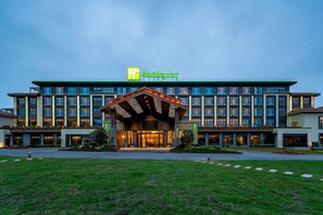 A Holiday Inn hotel with a modern facade, multiple floors, and a well-lit entrance. - Holiday Inn Jiuhua Mountain Hot Spring (Chizhou)