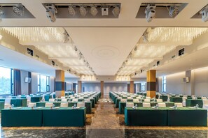 A conference room with rows of tables, ceiling lights, and large windows. - Holiday Inn Jiuhua Mountain Hot Spring (Chizhou)