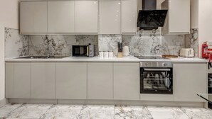 A modern kitchen with marble countertops, built-in appliances, and light-colored cabinetry. - 4 Br & 4 Bath Cowley House Sleep 10 With Parking (Oxford)