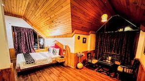Une pièce chaleureuse en bois, avec un lit, une petite table et une chaise.