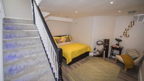 Ein Schlafzimmer mit Bett, Treppe, Teppich und einer Wand mit dekorativem Muster.