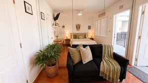 A room with a bed, a sofa, a dining table, and a potted plant. - Sand Vibes Studio Steps to Beach• Pool & Parking (Hollywood)