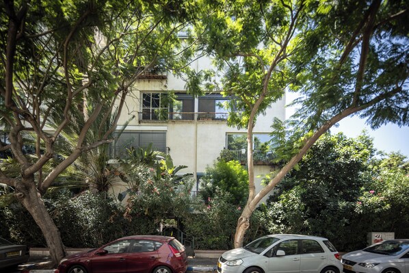 A street view with parked cars, trees, and a building with balconies. - Old North Green Oasis by Sea N' Rent (Tel Aviv)