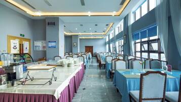 A conference room with long tables, chairs, and a projector screen.