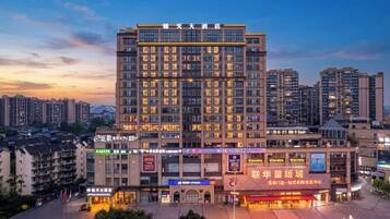 A multi-story hotel with a central atrium, surrounded by other buildings.