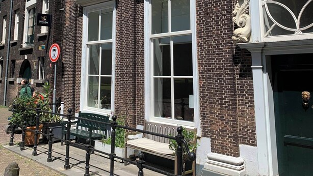 Een klassiek bakstenen gebouw met grote ramen en decoratieve steenwerk.