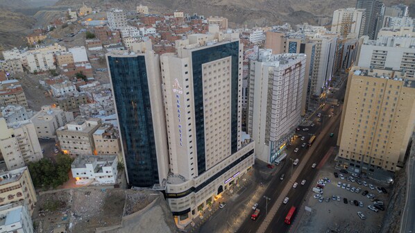 A high-rise hotel with multiple floors, a prominent glass facade, and a central entrance.
