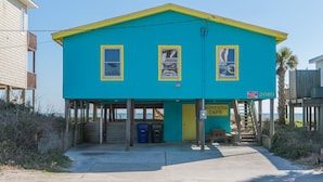 A two-story building with a blue and yellow exterior, a covered entrance, and a sign indicating it is a vacation ward.