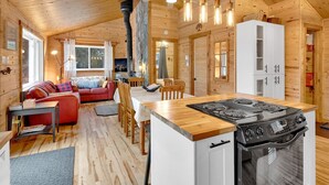A cozy cabin interior with a dining area, kitchen, and living room.