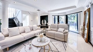 Ein geräumiges Wohnzimmer mit zwei Sofas, einem Couchtisch und einem großen Spiegel.