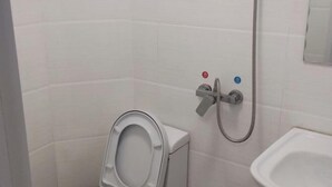 Un baño con inodoro, bidé y lavamanos.