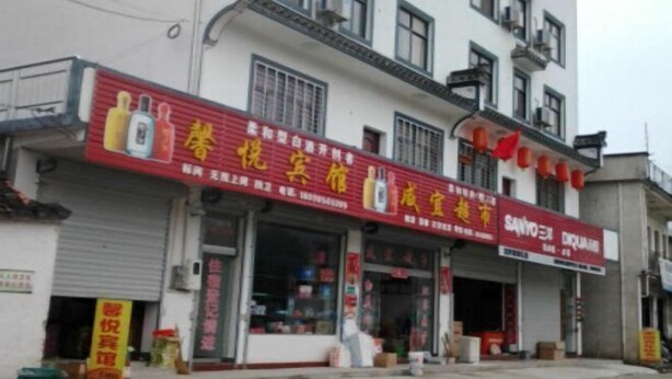Un edificio con varias fachadas comerciales, que incluye una farmacia y una tienda de conveniencia.