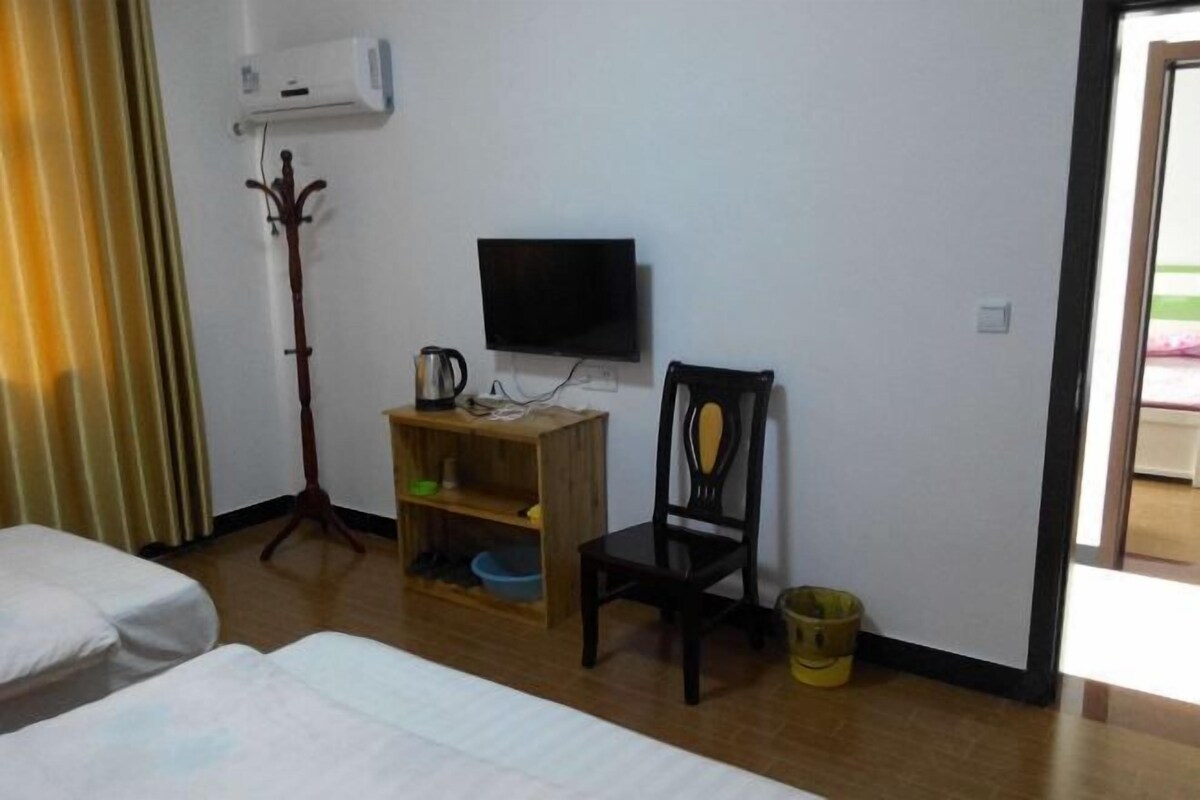 Una habitación de hotel con una cama, una mesita de madera, un televisor y una silla.