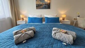 Une chambre d’hôtel avec un grand lit, deux oreillers, deux tables de chevet avec des lampes et un tableau au mur.