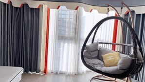 A room with a hanging chair, curtains, and a bed. - Fuding New Era Business Hotel (Fuding)