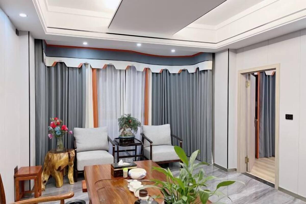 A modern living room with a sofa set, a coffee table, and a side table with a vase of flowers.
