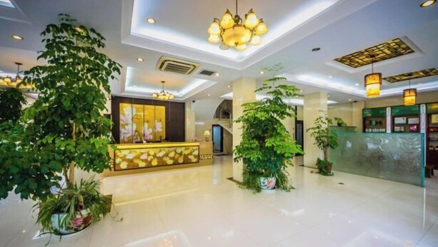 A spacious lobby with a reception desk, large potted plants, and modern lighting fixtures. - Fuding New Era Business Hotel (Fuding)