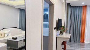 A modern living room with a sofa, coffee table, and a TV mounted on the wall. - Fuding New Era Business Hotel (Fuding)