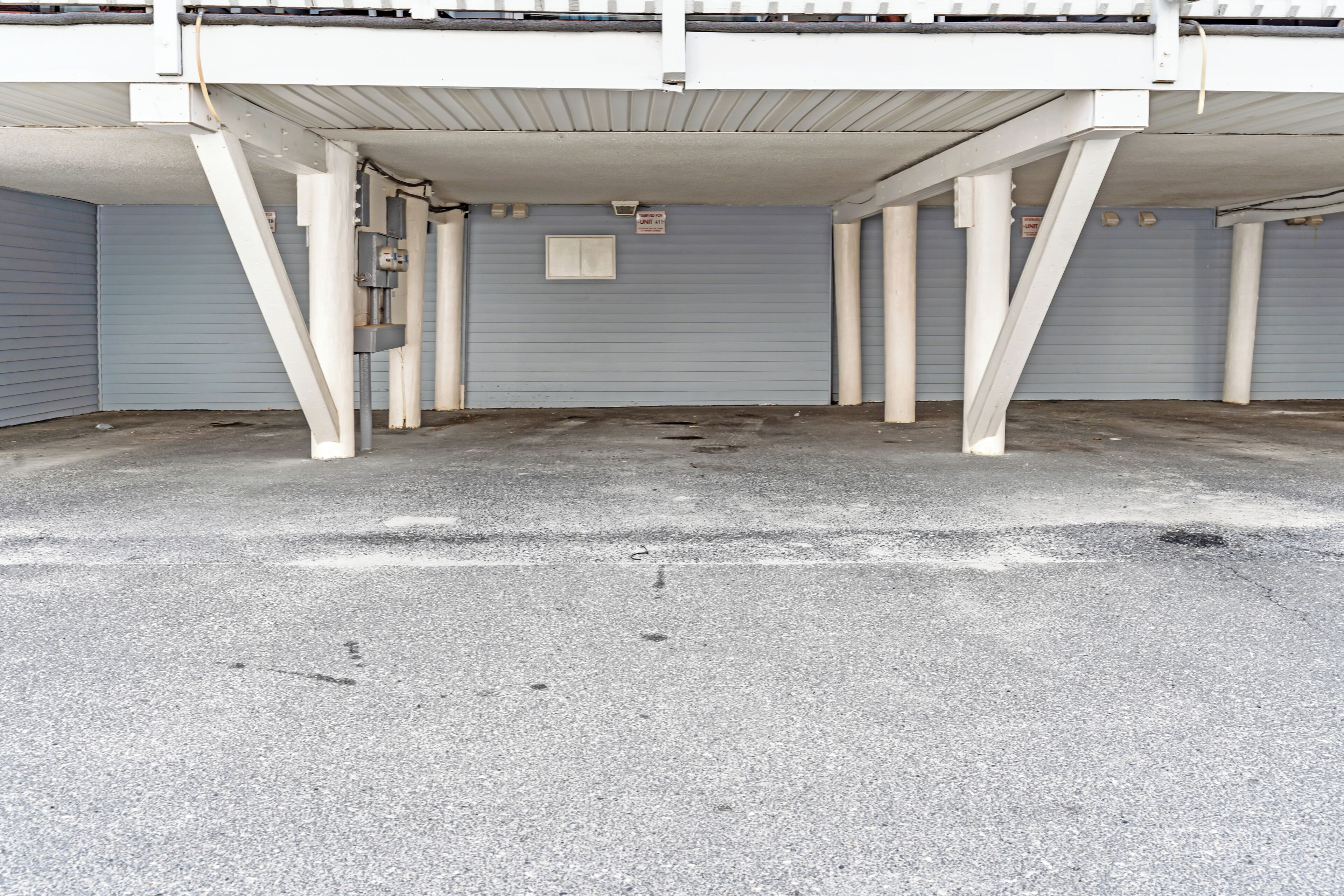 Un espace de stationnement vide, avec un sol en béton et une porte de garage fermée.