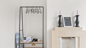 A room with a metal drying rack, a fireplace with candles, and a chalkboard with a list. - Reading Retreat Spacious 5 Bedroom House (Reading)
