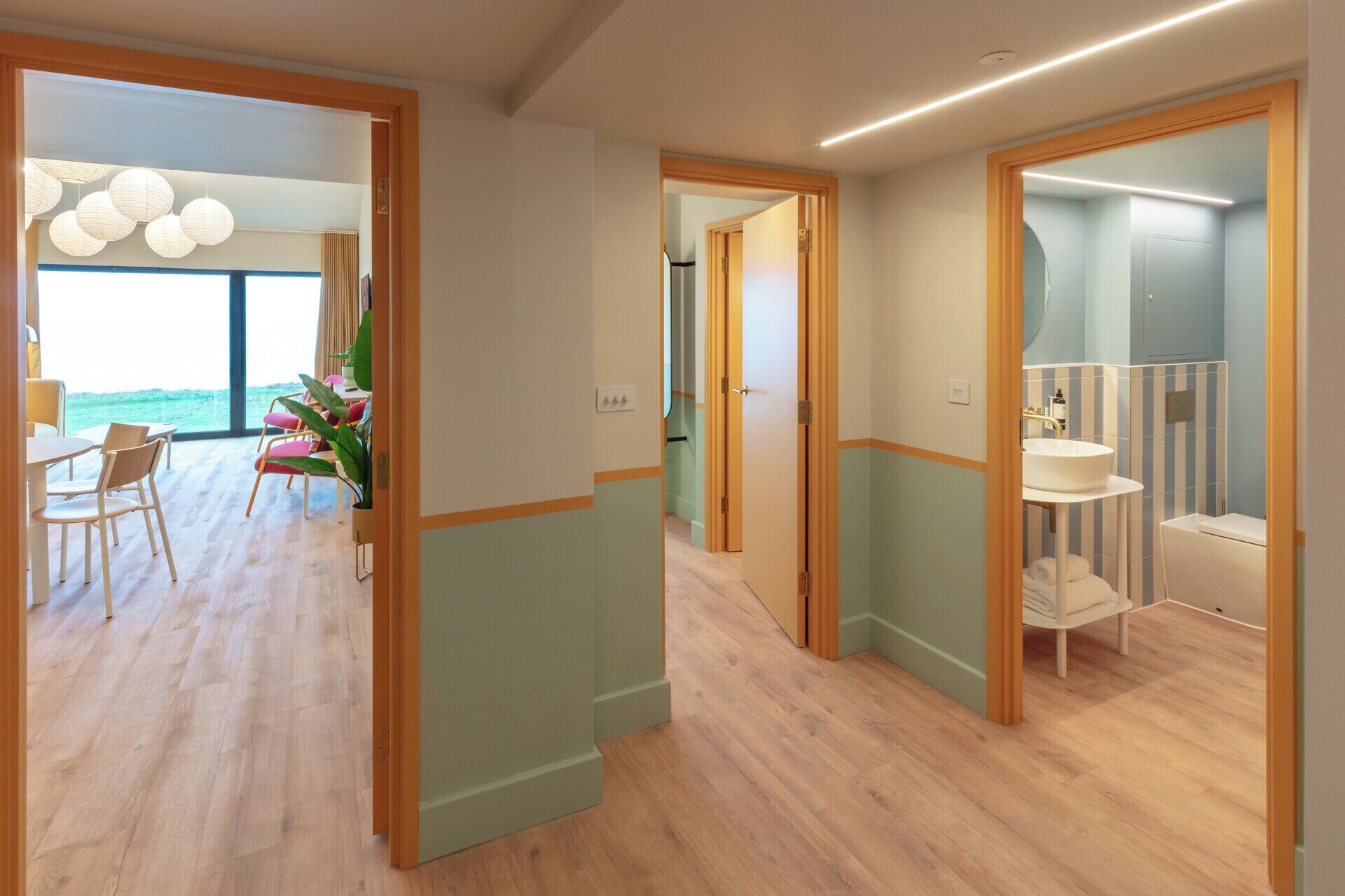 Een modern interieur met een eetgedeelte, een badkamer en uitzicht op zee.