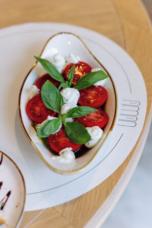 Un plato con ensalada de tomate y albahaca.