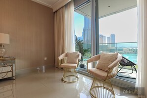 Relax in a stylish living room with a city view, featuring two armchairs and a large window.