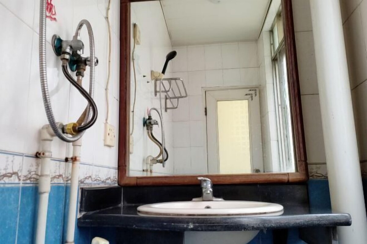 Un baño con lavamanos, espejo y ducha.