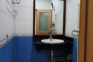 Un baño con lavamanos blanco, espejo y ducha.