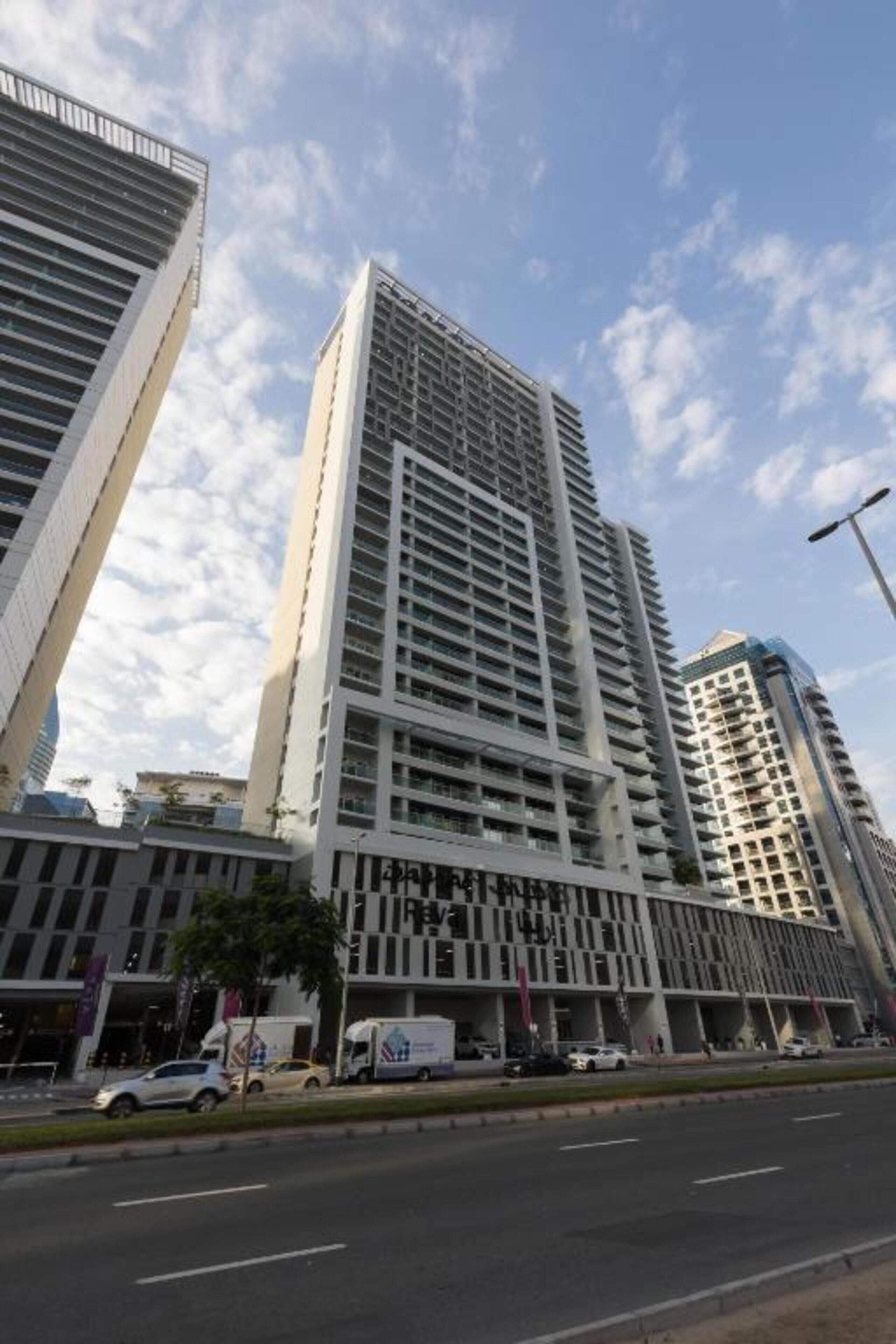 A modern high-rise building with a prominent central tower and a series of smaller surrounding structures.