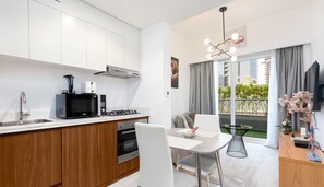 Apartamento standard, vista para a cidade | Cozinha privada | Geladeira, micro-ondas, fogão, cooktop