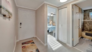 A hallway with a door leading to a bedroom, a bathroom with a bathtub, and a ceiling fan. - Family Retreats 5 minutes to the beach (Tarpon Springs)