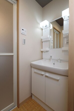 A bathroom with a white sink, mirror, and cabinet.
