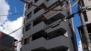 A multi-story building with balconies and a garage entrance.