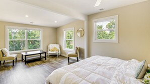 A bedroom with a large bed, two chairs, a bench, and a ceiling fan. - Waterfront Escape in Cub Run w/ Deck & Hot Tub! (Cub Run)
