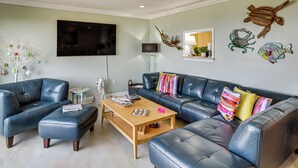 A living room with a sofa, coffee table, and decorative wall art. - Waterfront Biloxi Condo: Gulf-view Balcony! (Biloxi)