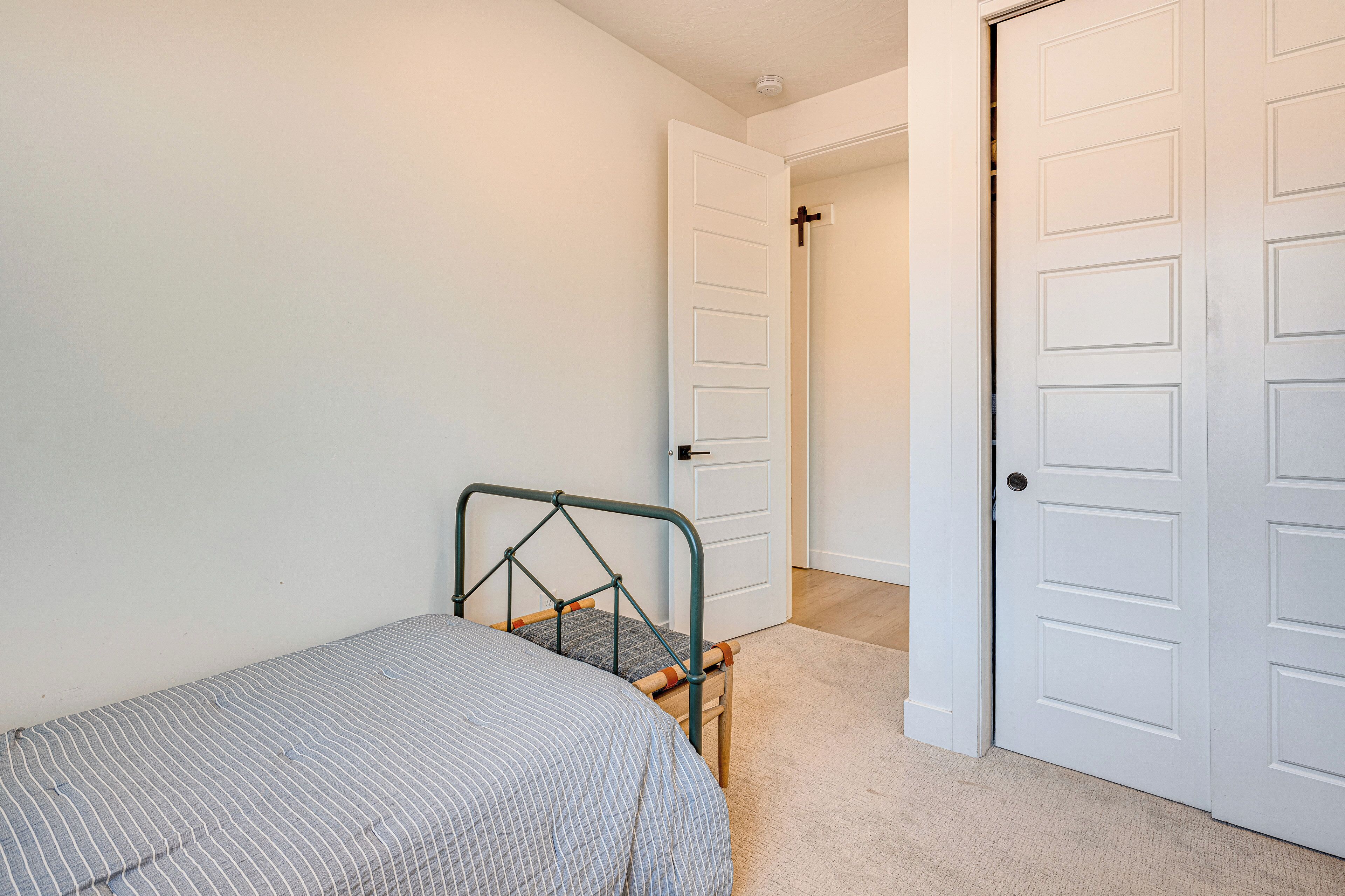 Een slaapkamer met een bed, een stoel en een deur.