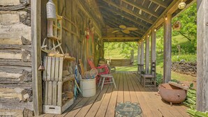 A rustic wooden porch with a ceiling fan, rustic decor, and a rustic outdoor setting. - Ferrum Rustic Cabin in the Valley w/ Fire Pit (Ferrum)