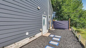 A building with a gray exterior, a white door, and a small porch area with steps leading to a covered entrance. - Cozy Sturgis Retreat - Walk to Main St & Saloons! (Sturgis)