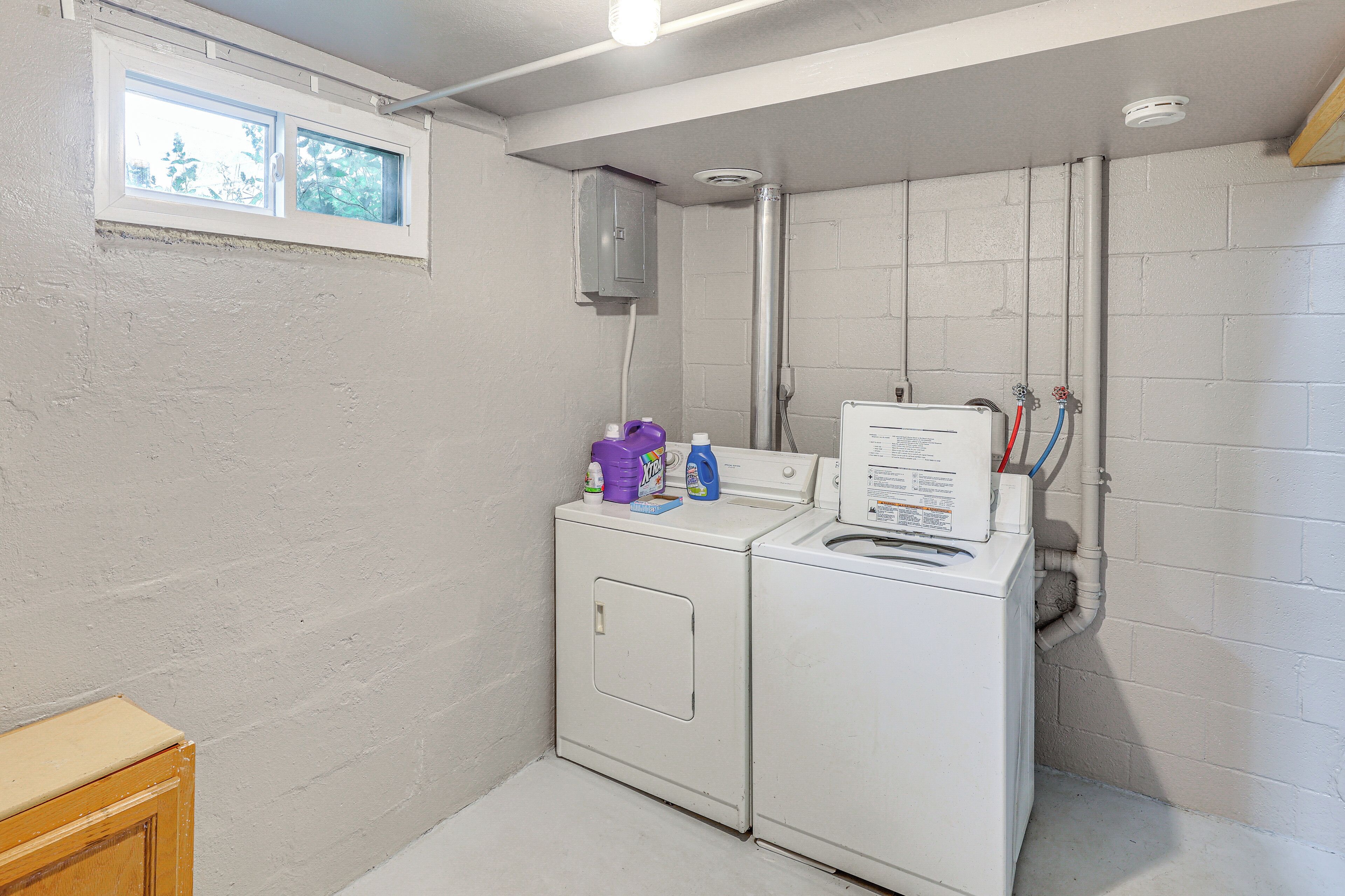 A laundry room with a washing machine, dryer, and a window.
