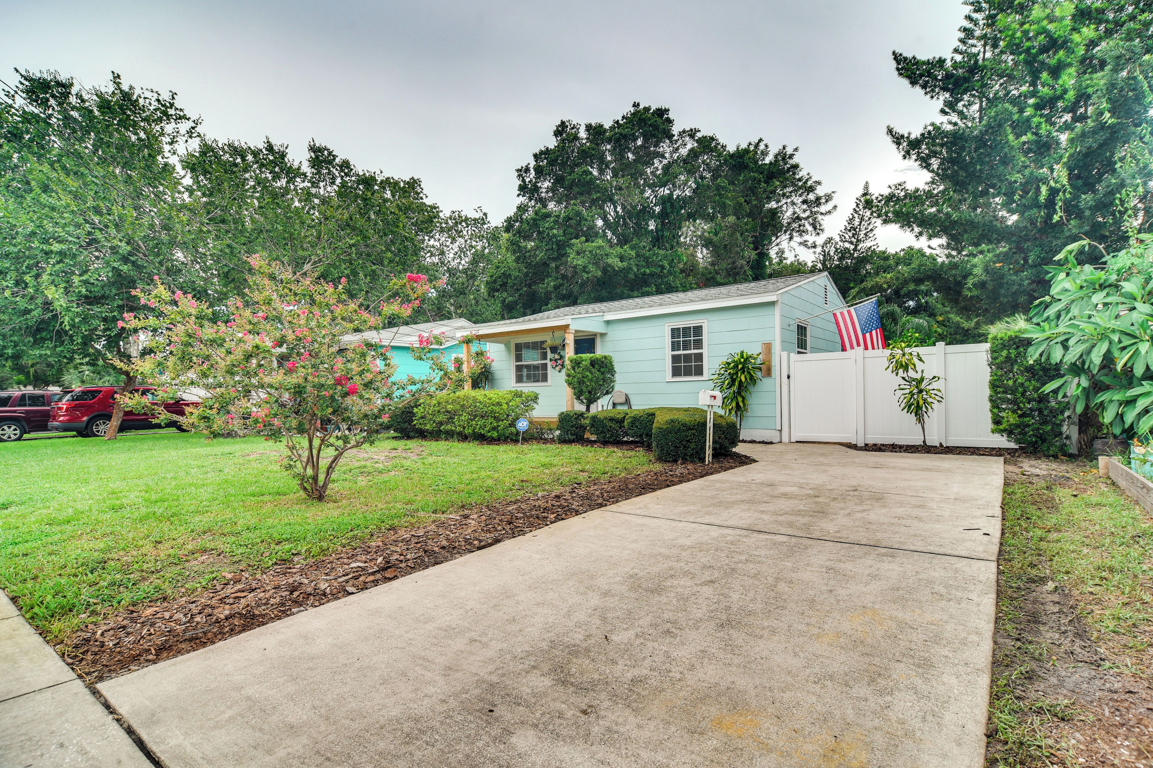 A single-story house with a front yard, a mailbox, and a small American flag.